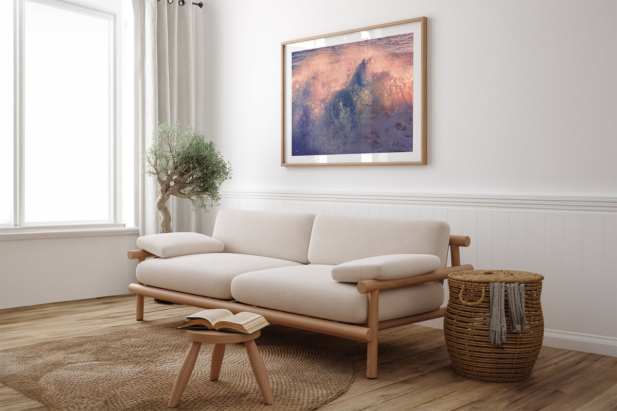 Dusk Burst print shown framed in oak above a linen couch.