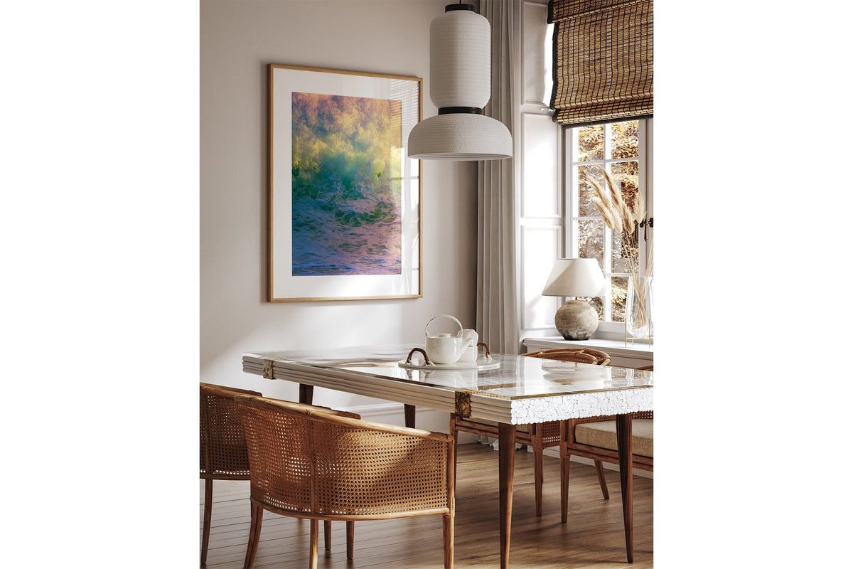 Happy Face print shown framed in oak above a dining table.
