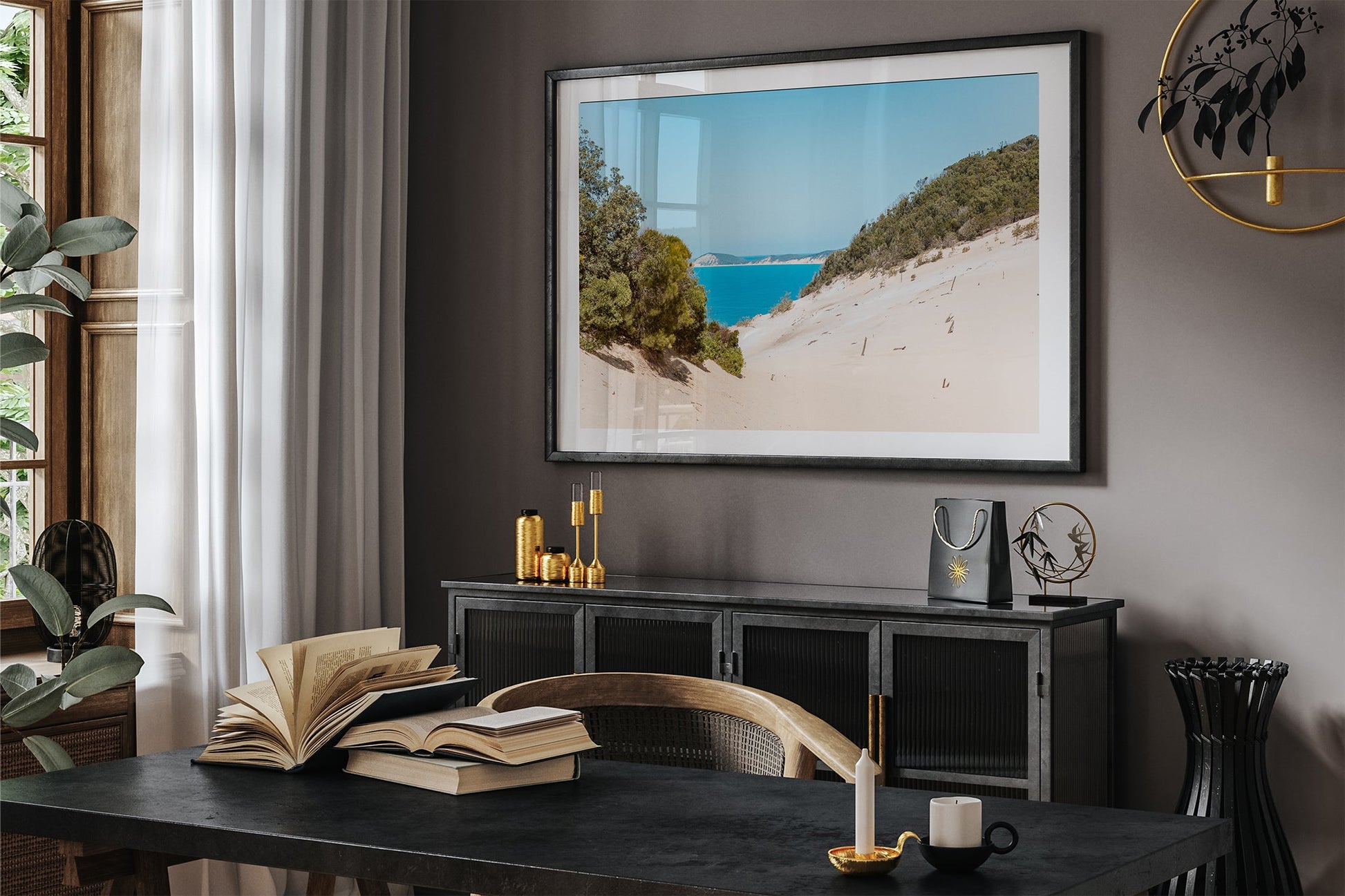 Rainbow Beach dune print shown framed in black above a sideboard in a dark toned room.