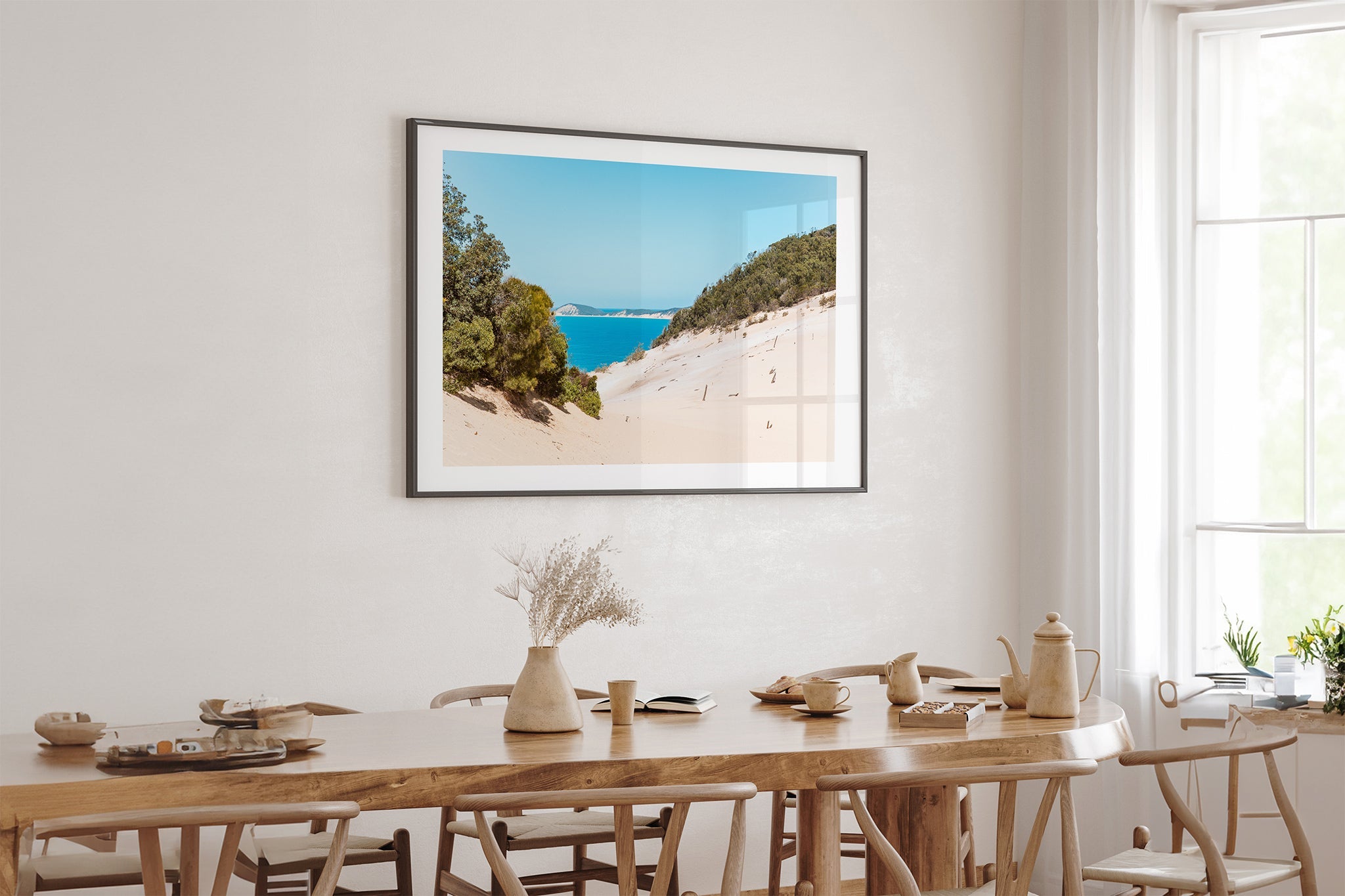 Rainbow Beach dune print shown framed in black above an oak dining table.