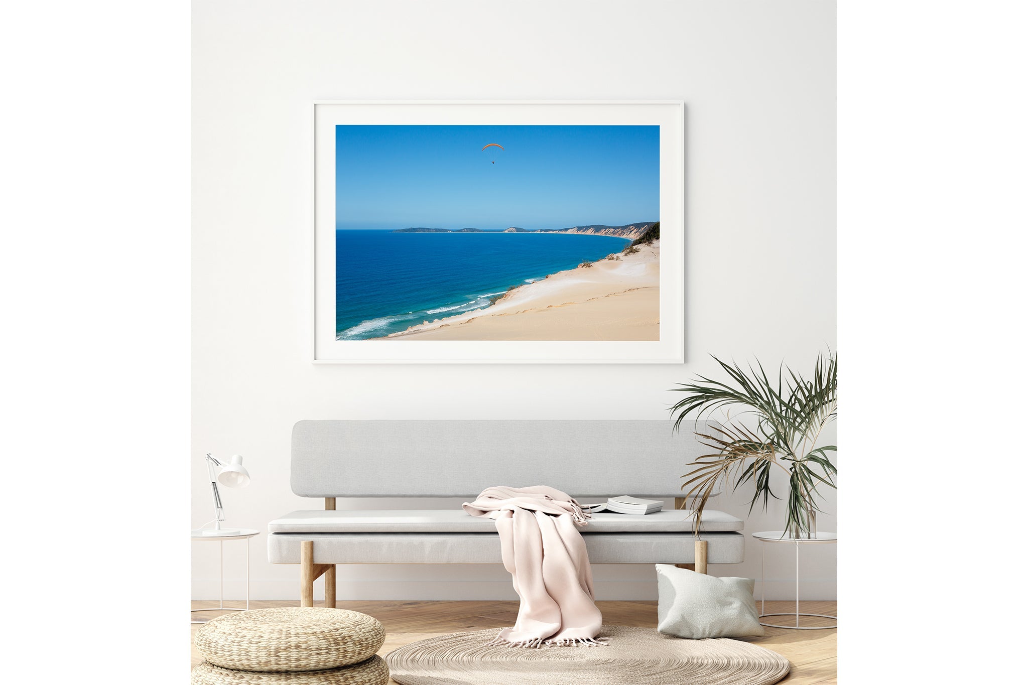 Rainbow Beach paraglider print shown framed in white above a bench seat.