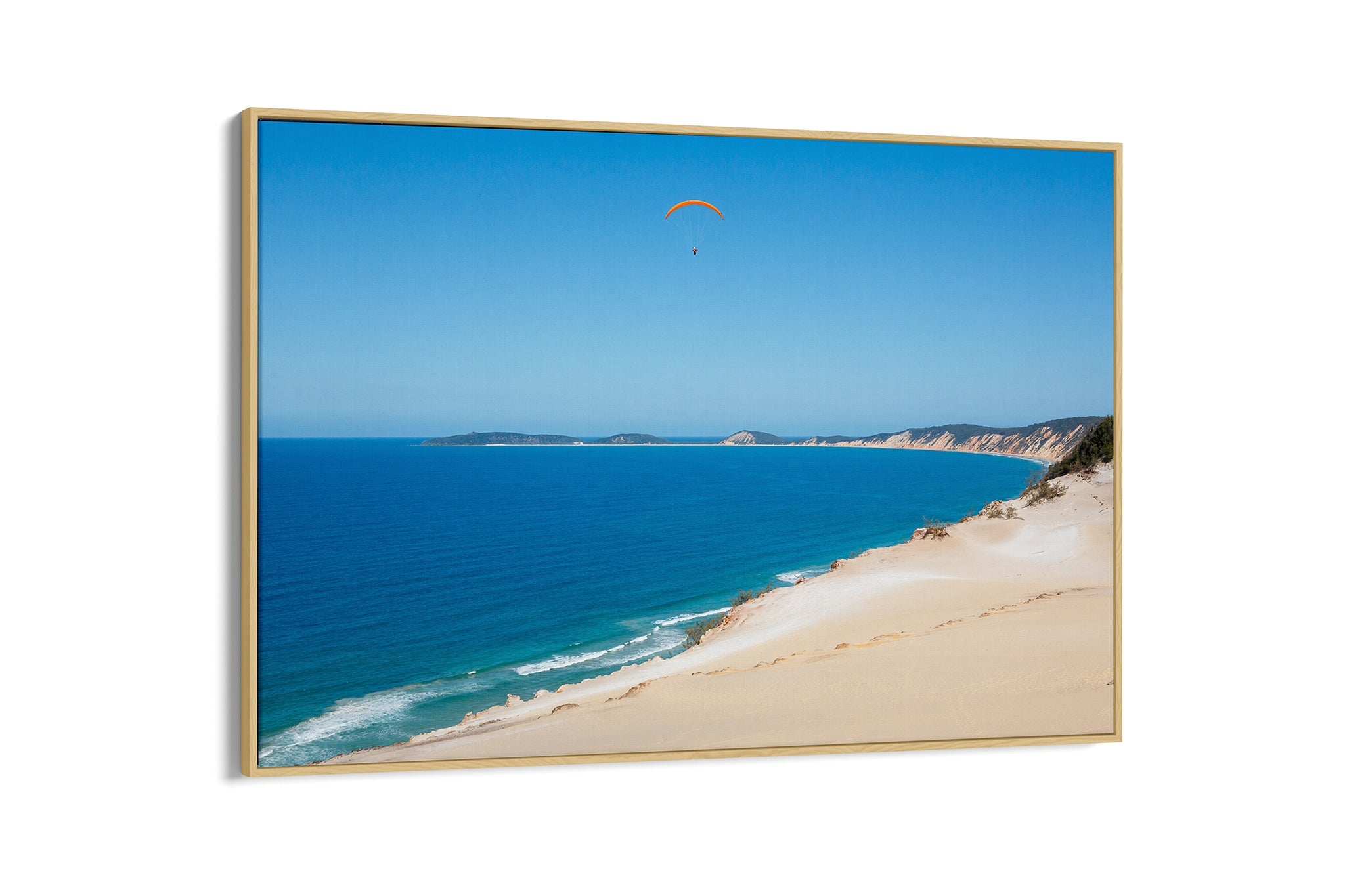 Rainbow Beach paraglider print shown as an oak float frame canvas.