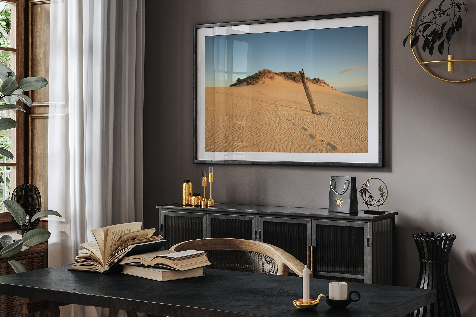 Rainbow Beach dune print shown framed in black above a sideboard in a dark toned room.