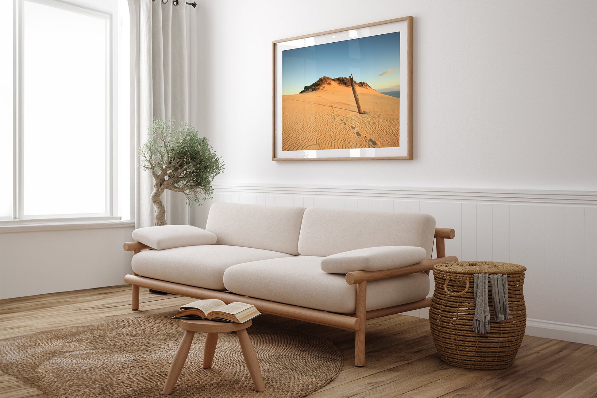 Rainbow Beach dune print shown framed in oak above a couch.