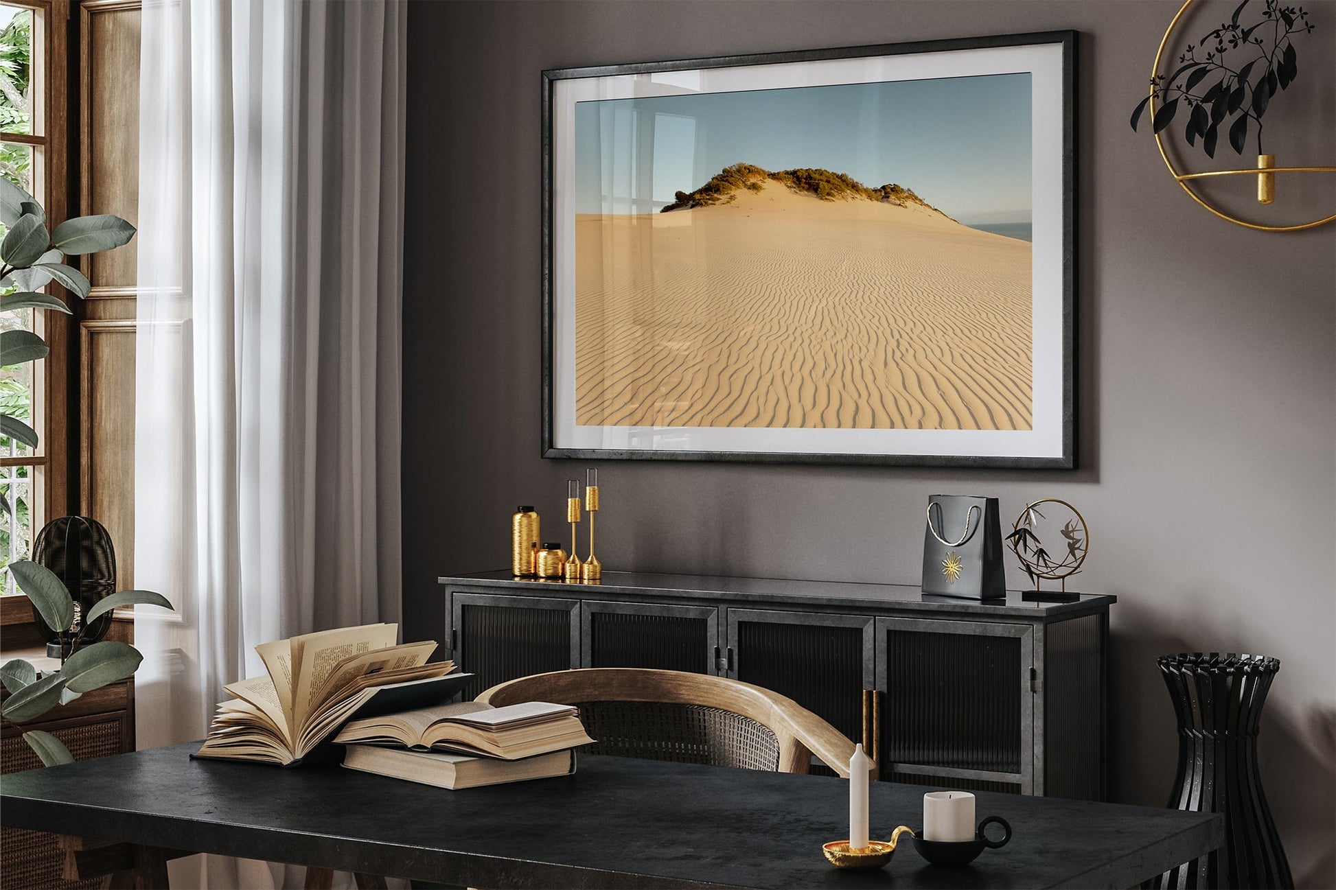 Rainbow Beach golden dunes print shown framed in black above a sideboard in a dark toned room.