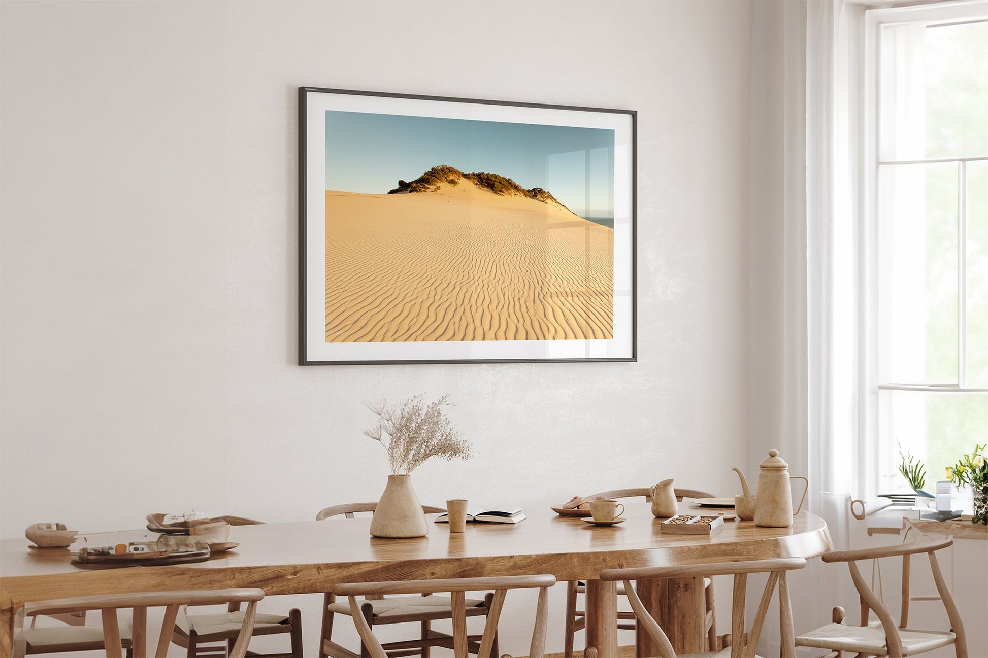 Rainbow Beach golden dunes print shown framed in black above an oak dining table.