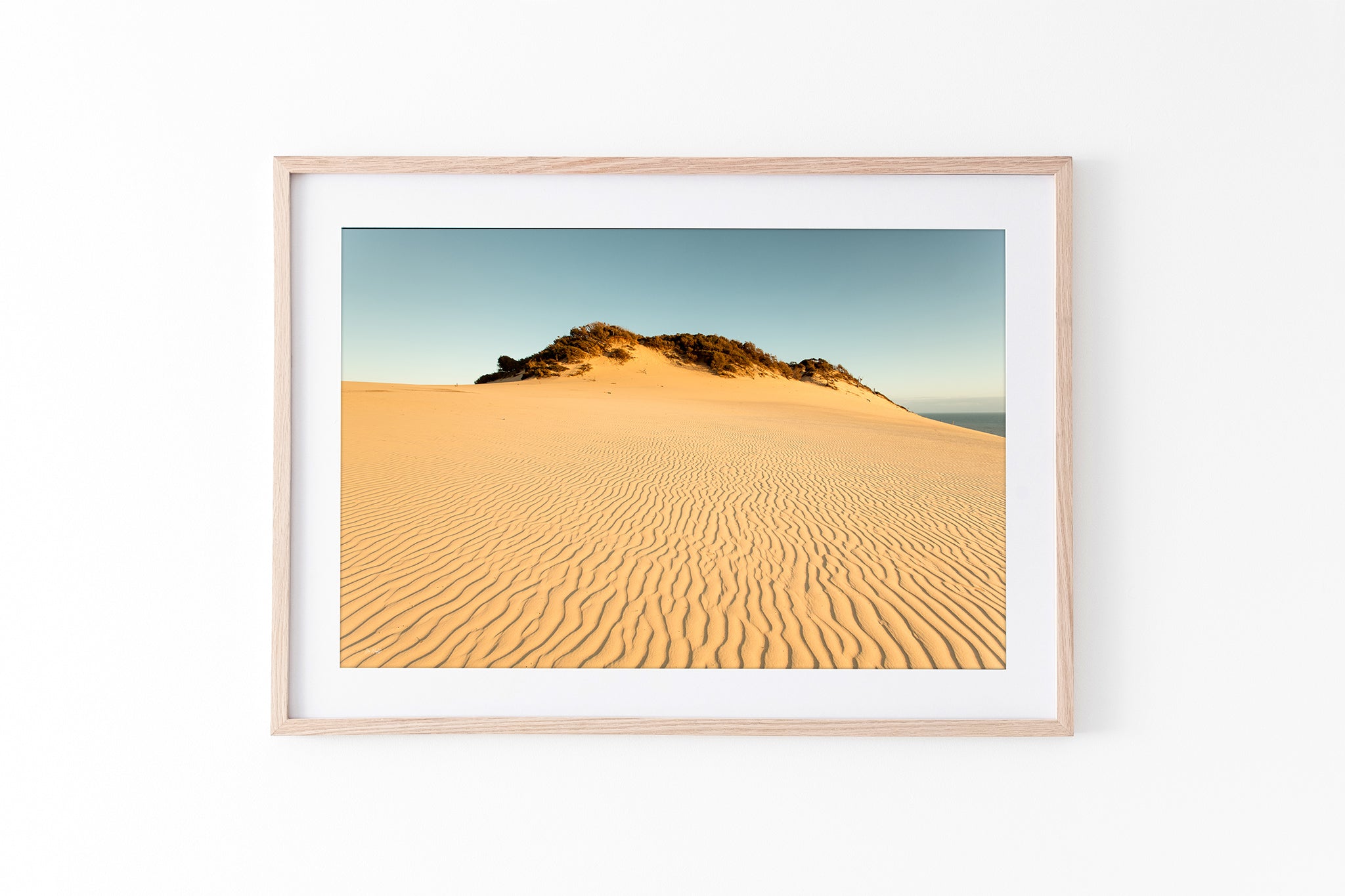 Rainbow Beach golden dunes print shown framed in oak.