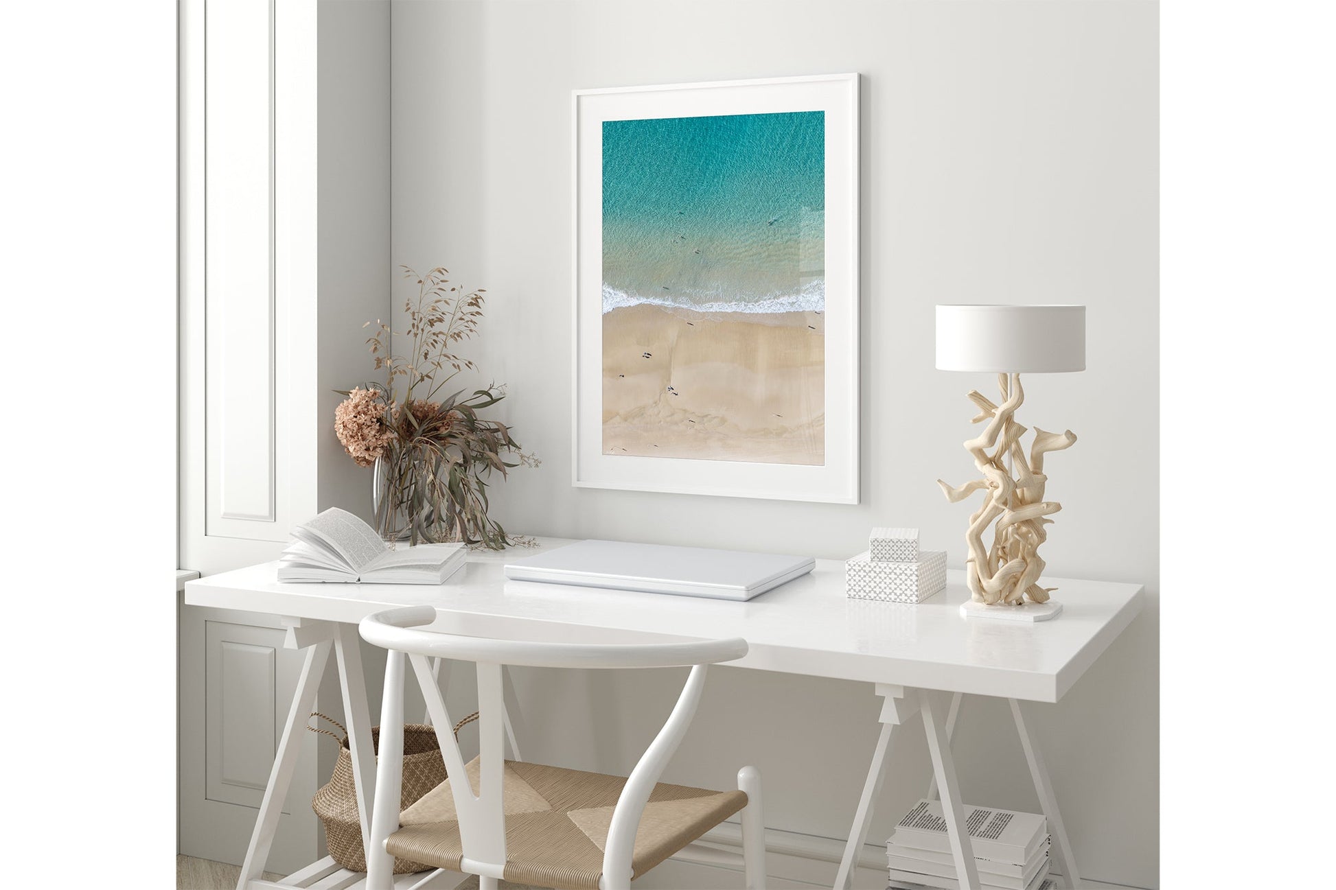 The Turquoise Shallows print shown framed in white in a coastal-styled room.