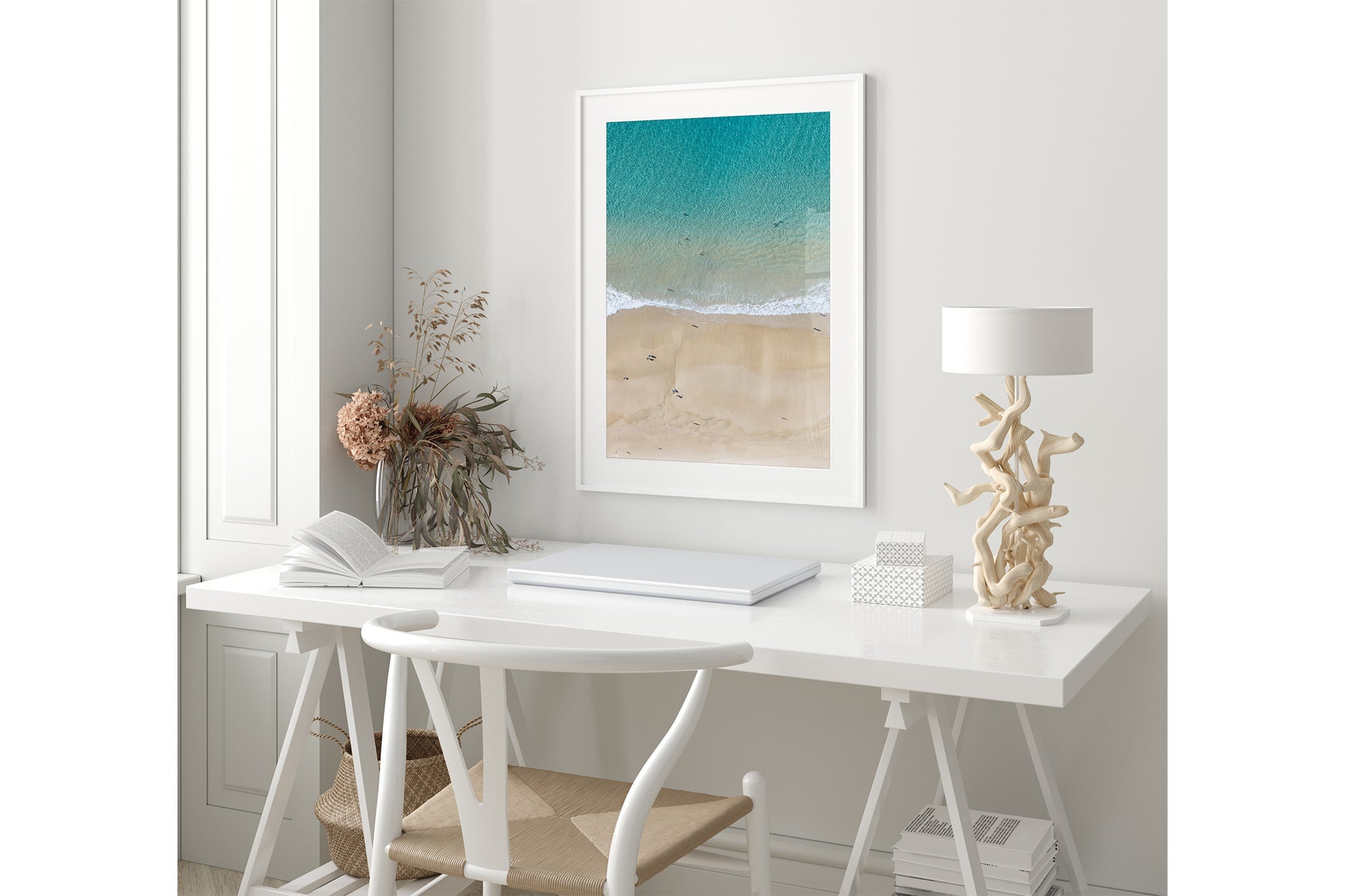 The Turquoise Shallows print shown framed in white in a coastal-styled room.