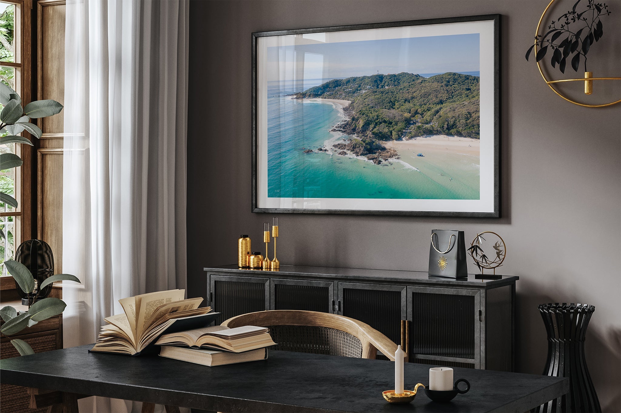 Cape Byron aerial print shown framed in black in a dark room.