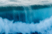 An abstract deep blue wave face streaked with spray crashing into white foam, a motion blur ocean wall print.