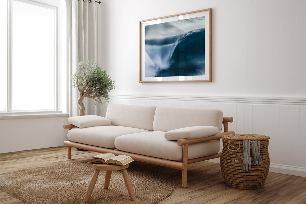 Impact Blur wave print shown framed in oak above a linen couch.