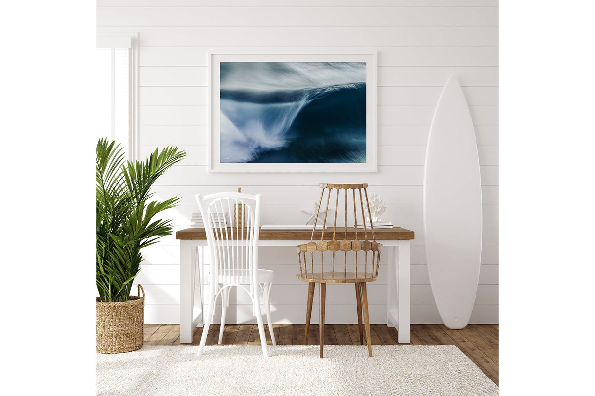 Impact Blur wave print shown framed in white on a white shiplap wall beside a desk.