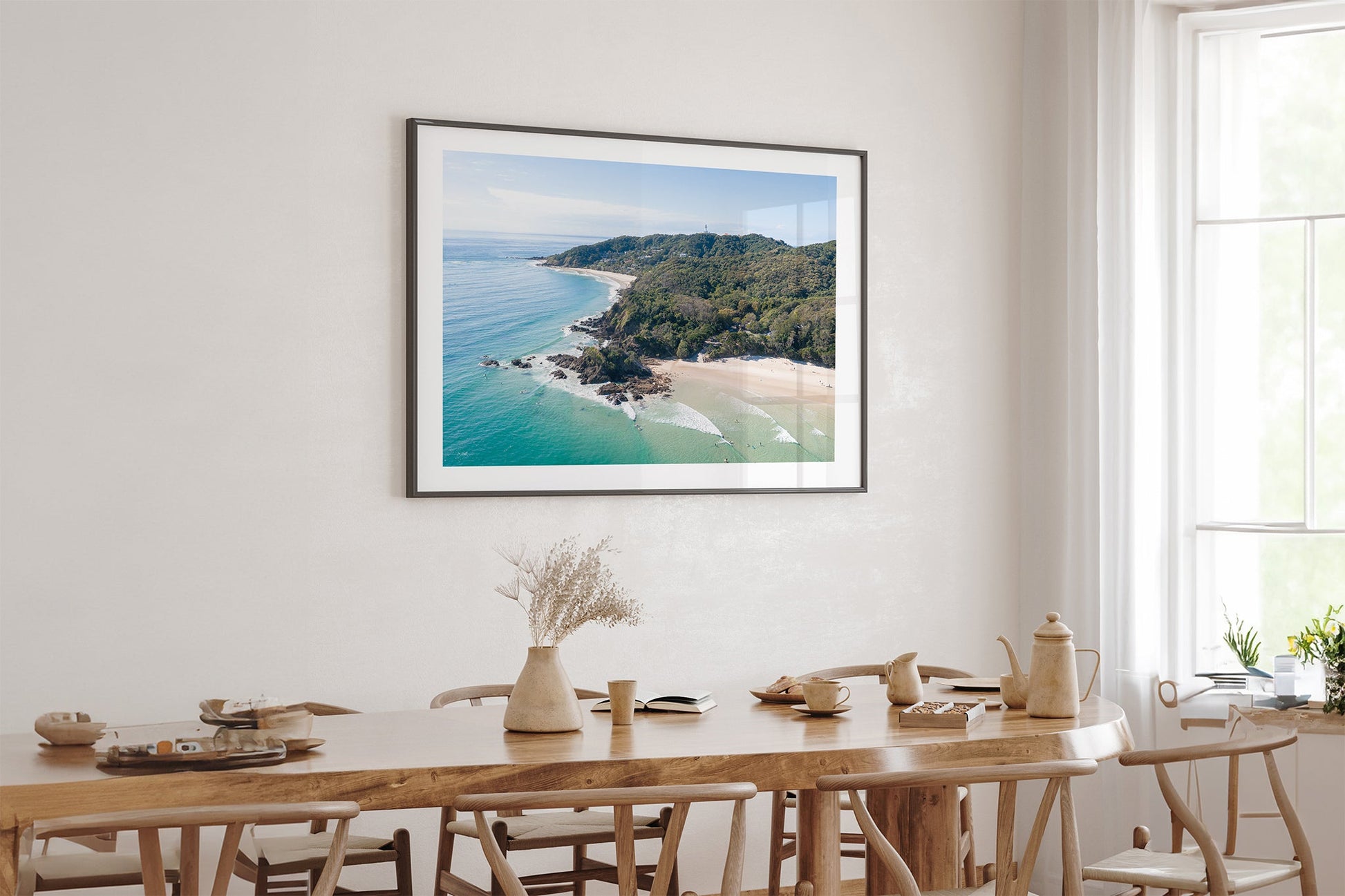Lighthouse Point print shown framed in black above an oak table.