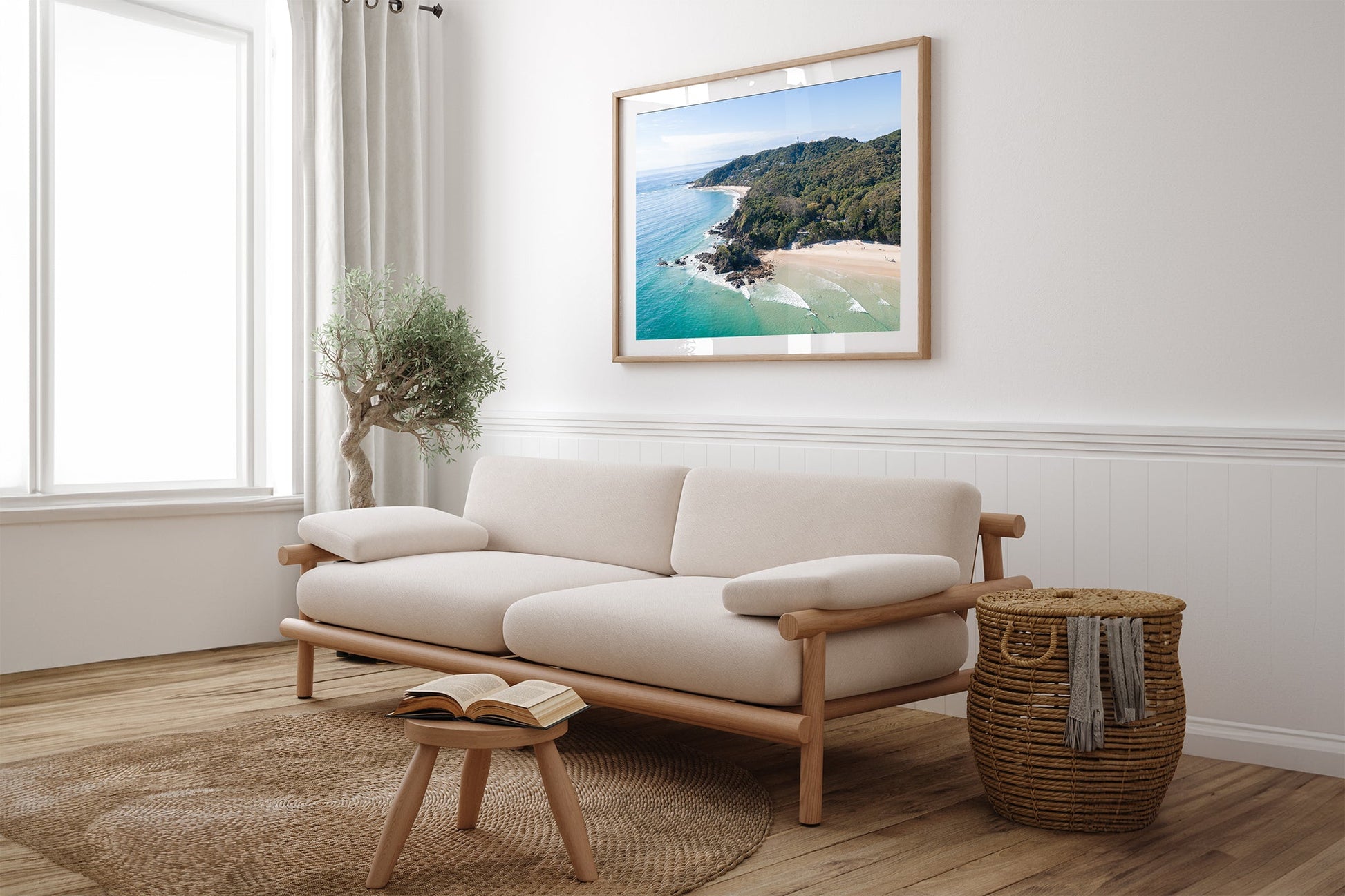Lighthouse Point print shown framed in oak above a couch.