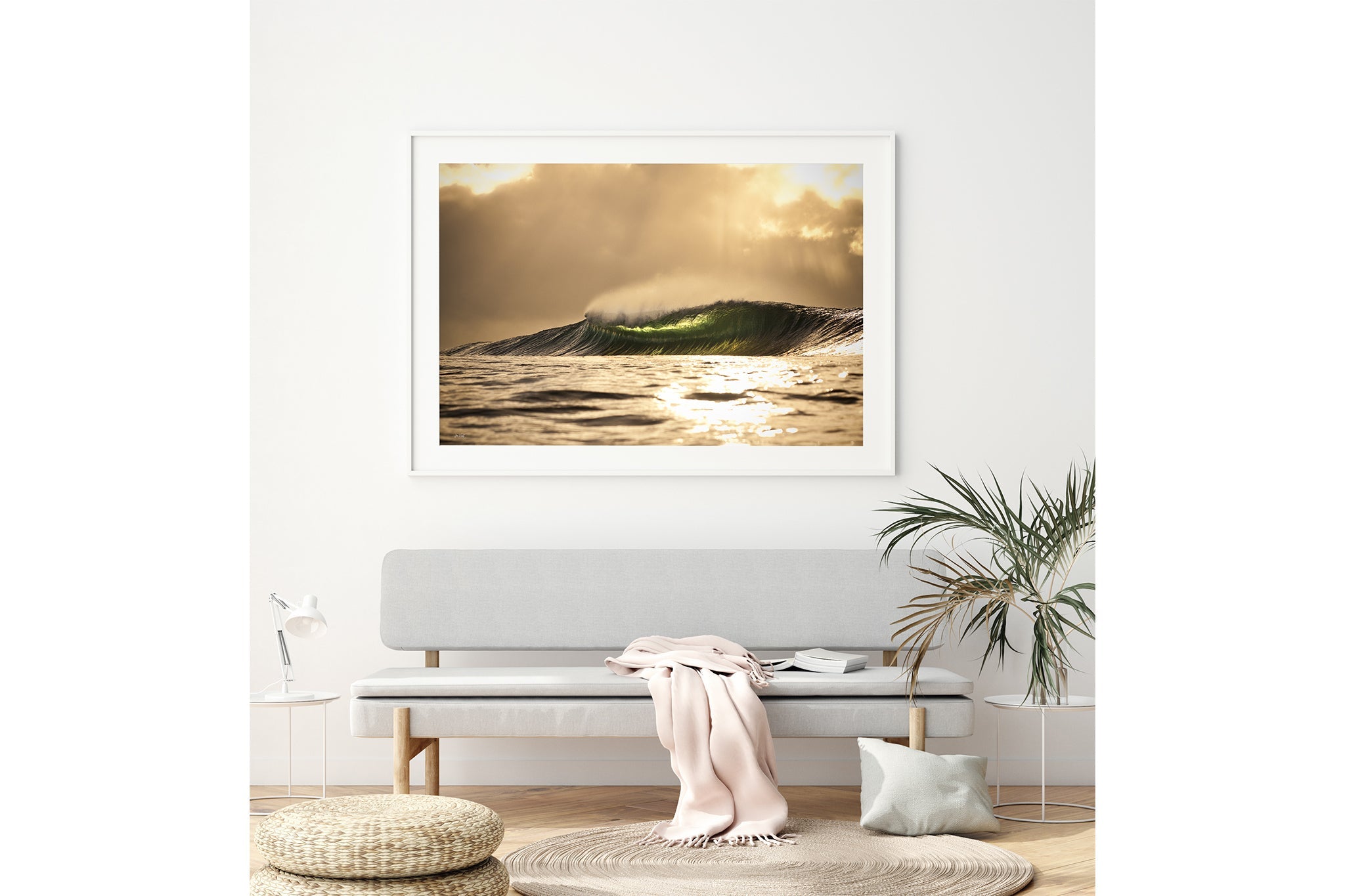 Golden sunset wave print shown framed in white, hung above a grey bench seat in a neutral toned living room.