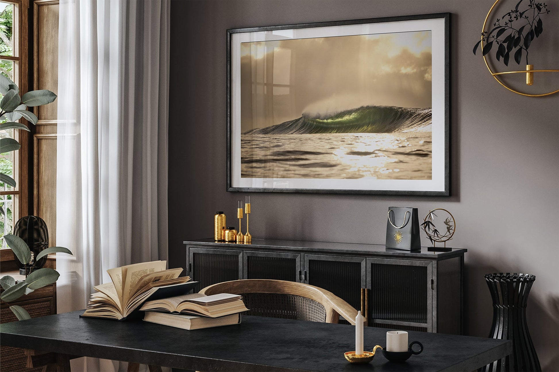 Golden sunset wave print shown framed in black, hung in a moody dark toned study with gold accent decor.