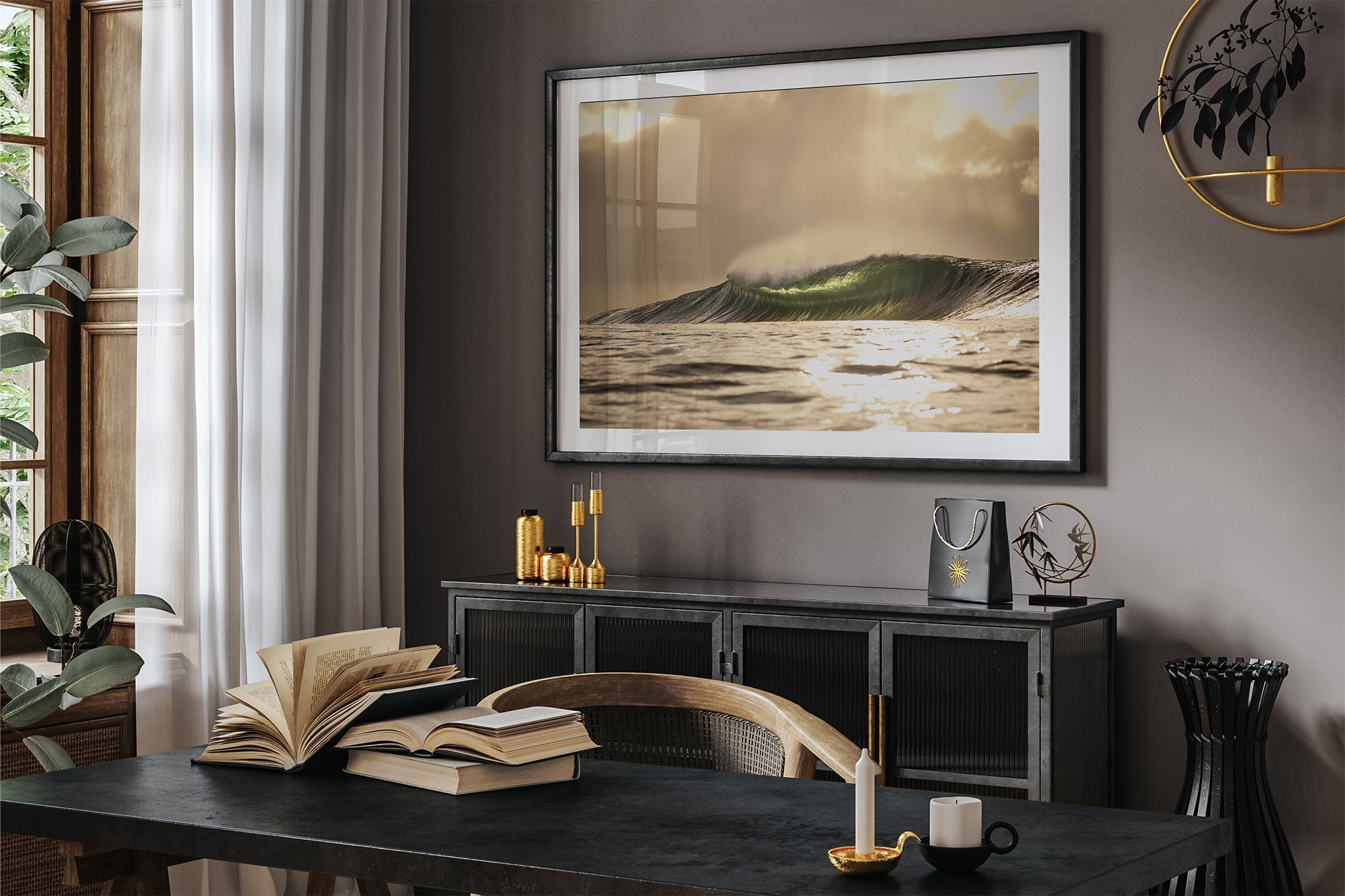 Golden sunset wave print shown framed in black, hung in a moody dark toned study with gold accent decor.