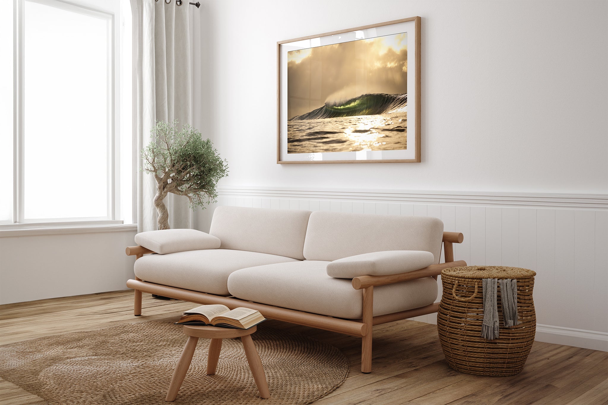 Golden sunset wave print shown framed in oak, hung above a cream sofa in a light, plant filled living room.