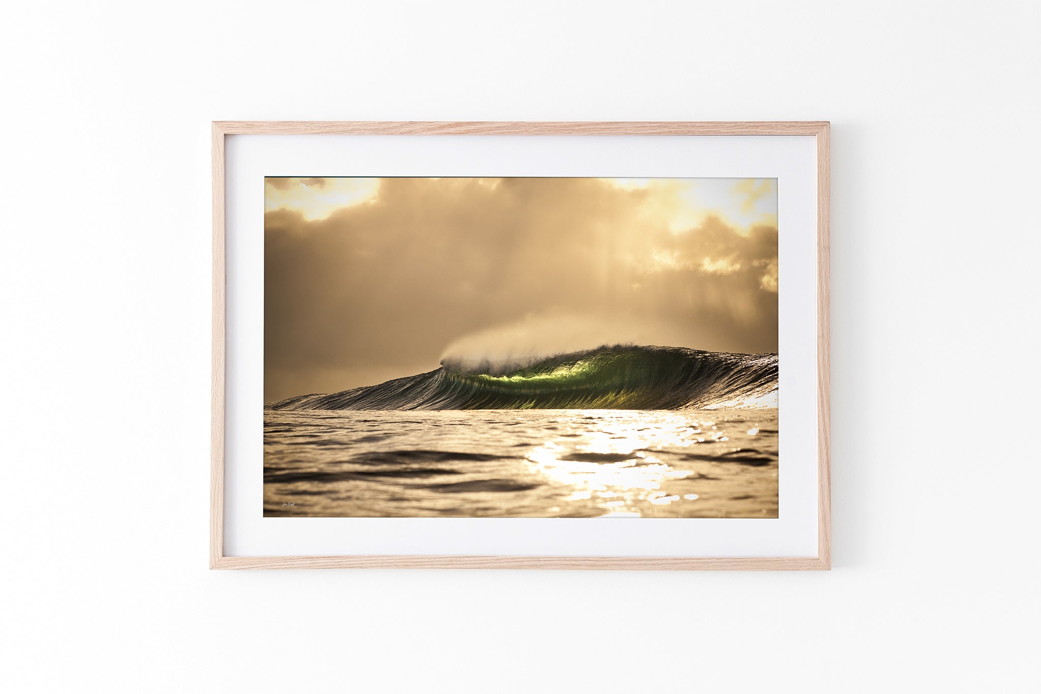 Golden sunset wave print shown framed in oak against a plain white studio background.