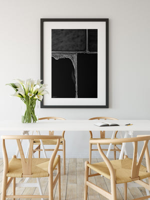Black and white abstract wall print in black frame with white wall