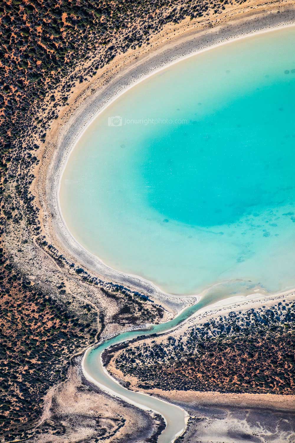 Aerial image of salt pond in Western Australia with blue and red sand