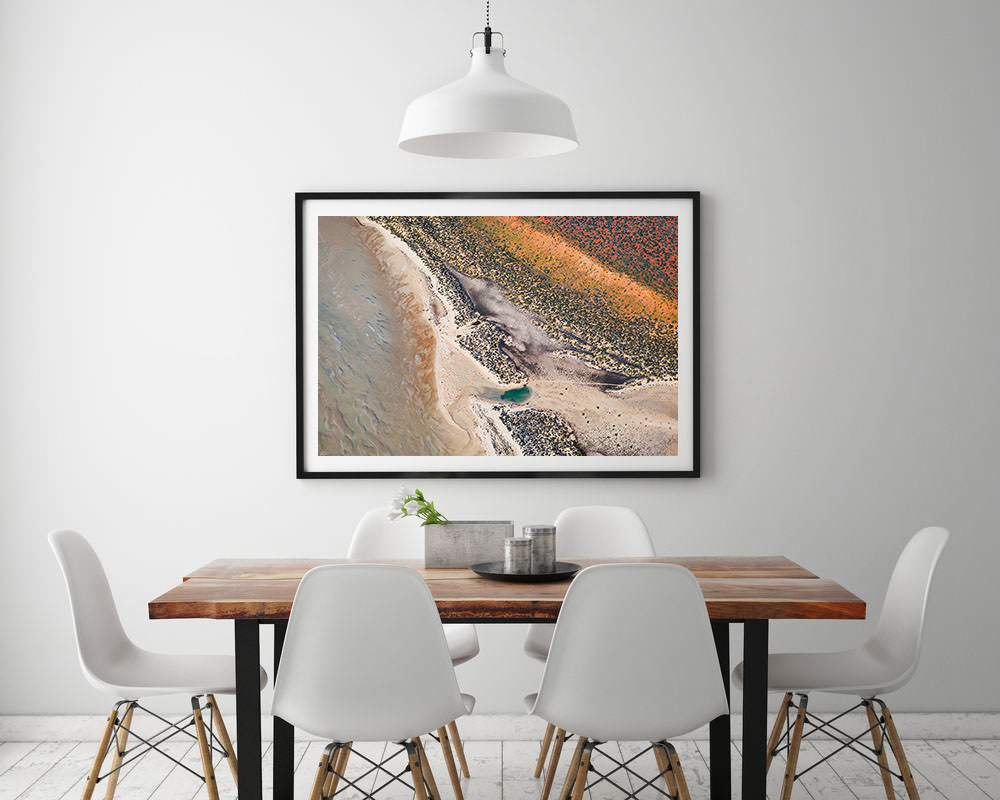 White framed earth tone abstract artwork on wall with pastel colours