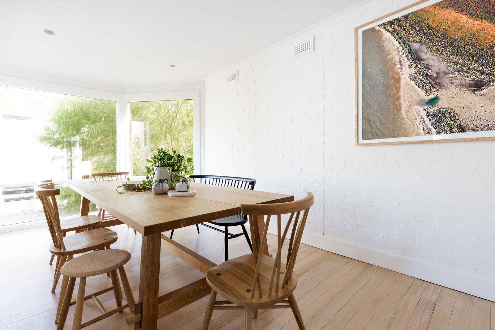 White framed earth tone abstract artwork on wall with pastel colours