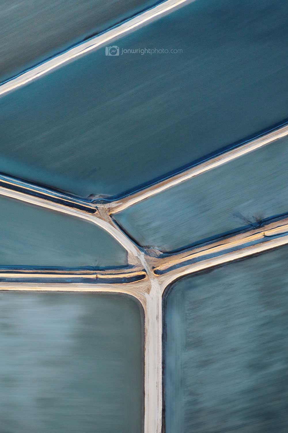 Brushed abstract photography of salt ponds with muted blue tones