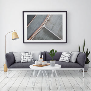 Abstract aerial art and photography of brushed grey salt ponds in black frame hanging on wall with gray chair