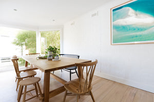 Coastal living space with beach style print framed in oak