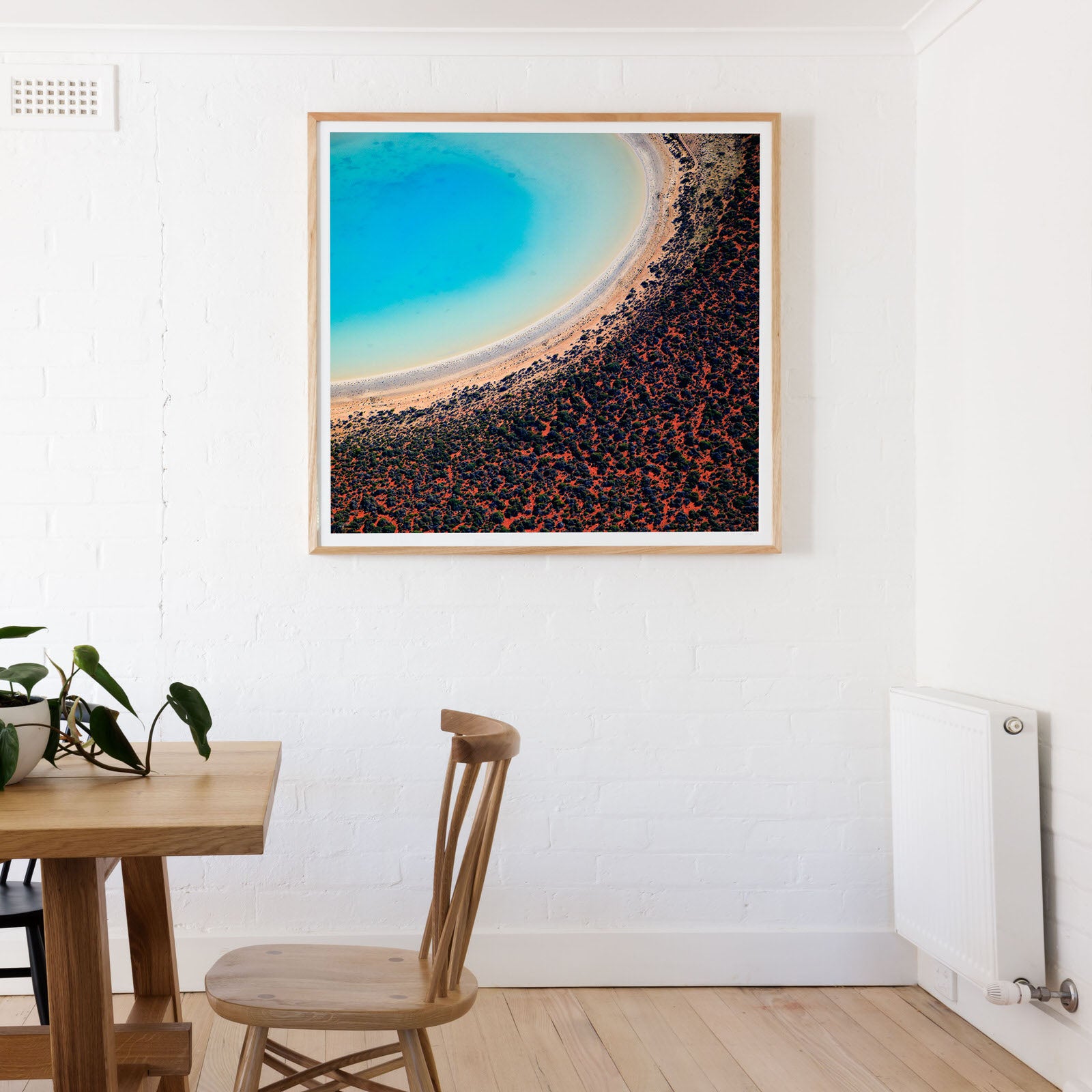 Tasmanian Oak Framed print on white wall with abstract print of red and blue sands