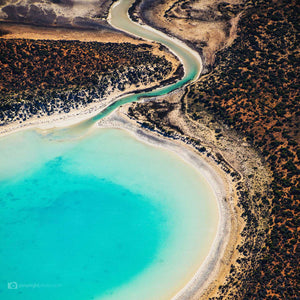 Blue water inlet with red sand square abstract aerial art