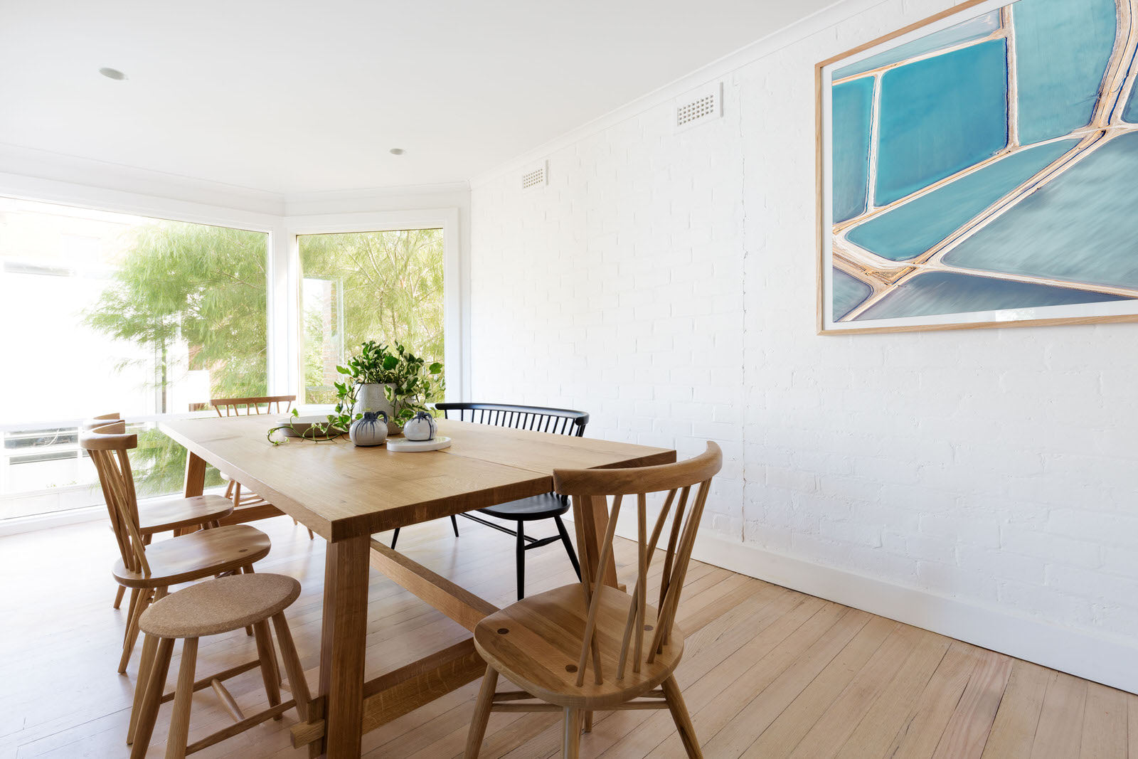 Clean Scandinavian styled room with abstract blue art hung with oak frame