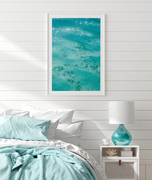 beach print in white frame hanging on wall